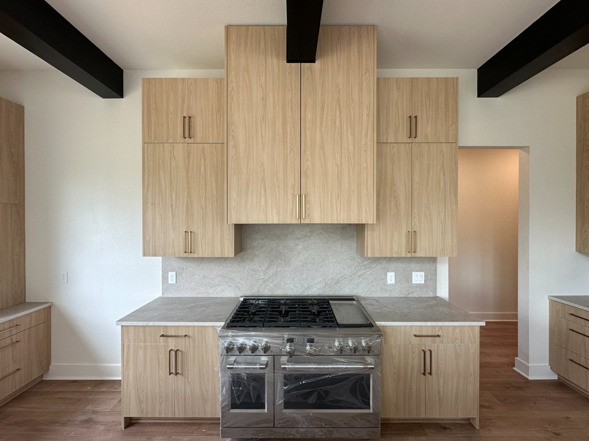 Frameless oak kitchen cabinets with a marble backsplash