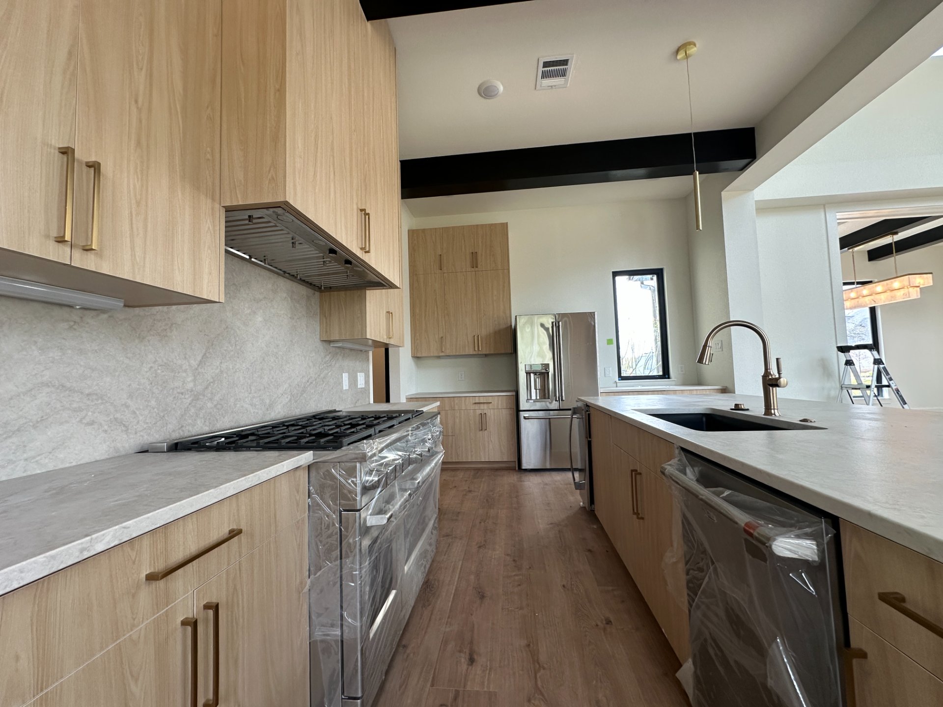 Modern oak kitchen with brass hardware and a gas range