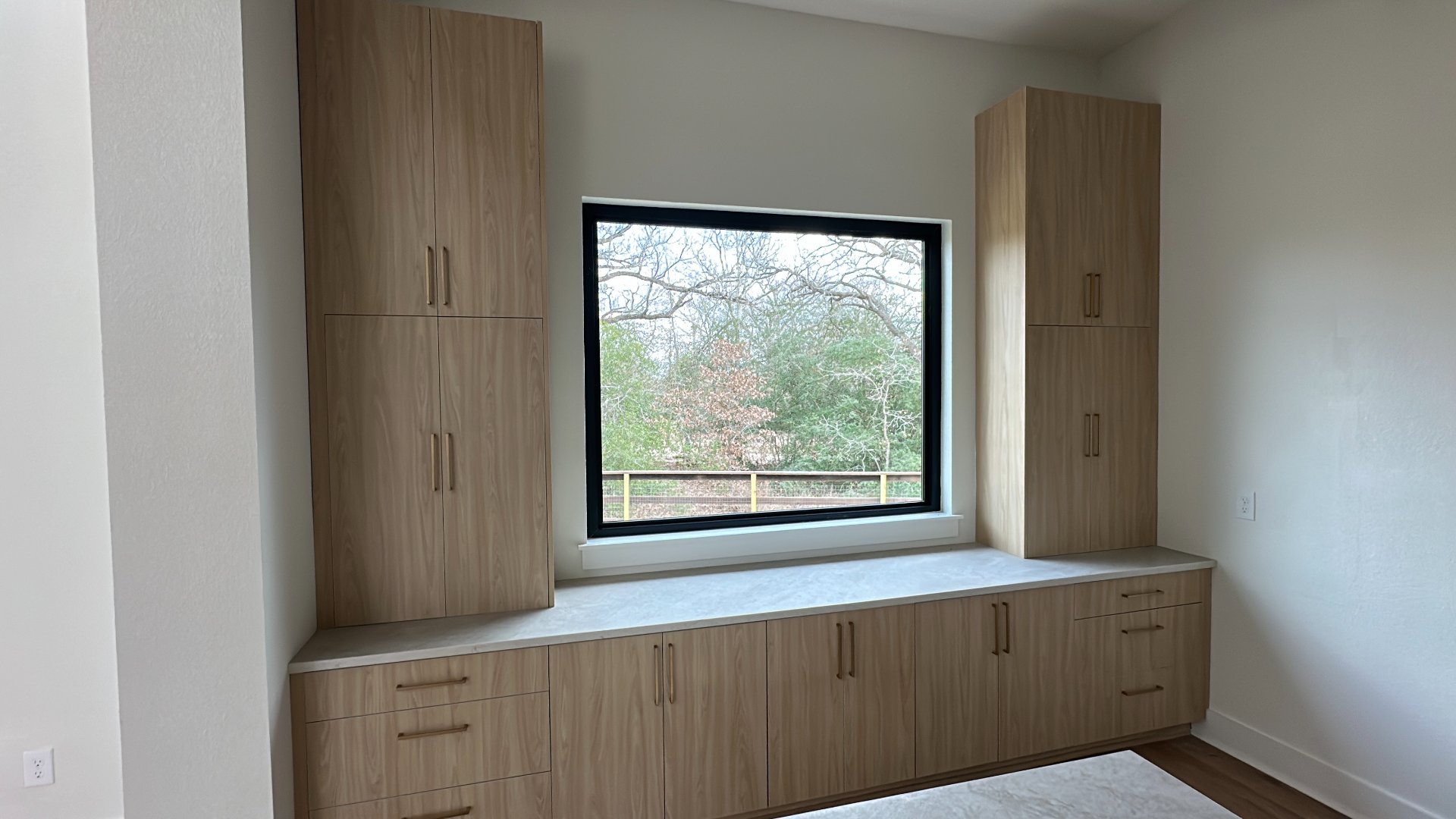 Custom built-in oak cabinetry along a window wall